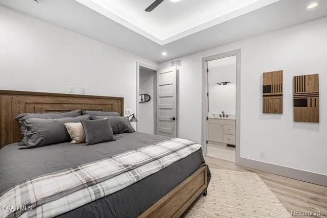 a bedroom with a large bed and wooden floor