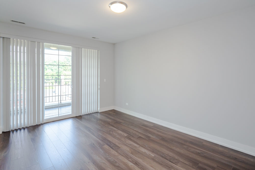 1202 Waukegan Road, Unit 410 Glenview, IL 60025 - Photo 13 of 15 a view of an empty room with wooden floor and a window
