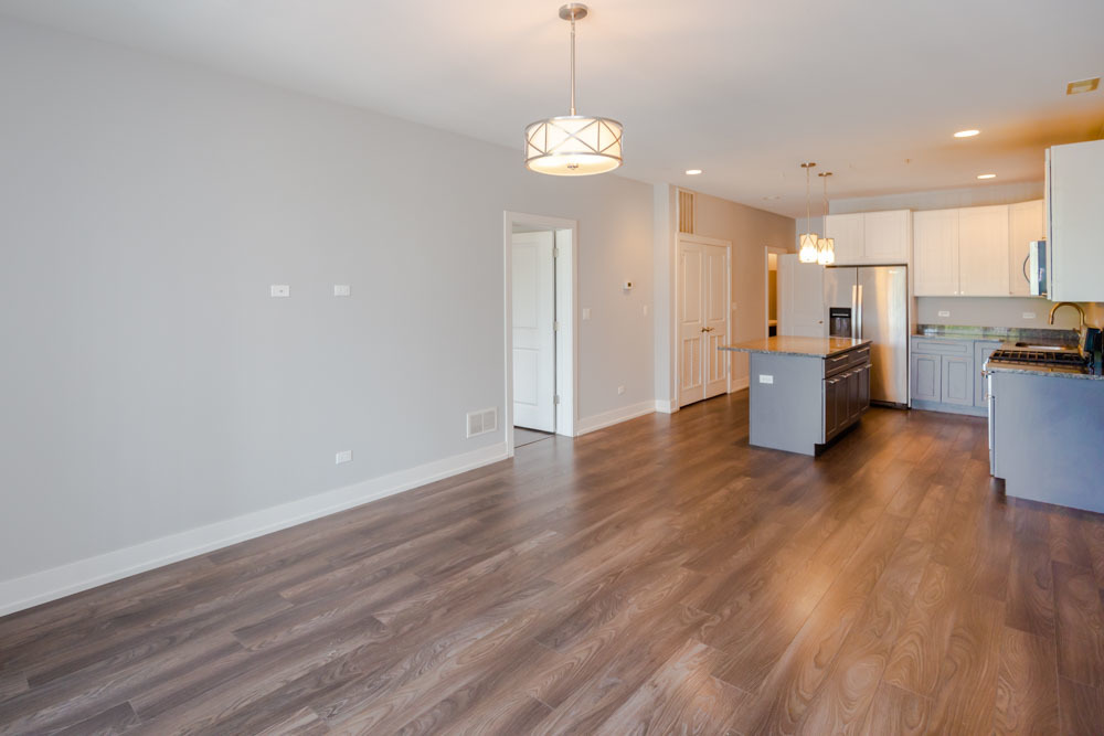 1202 Waukegan Road, Unit 410 Glenview, IL 60025 - Photo 3 of 15 a view of a kitchen and dining room with wooden floor