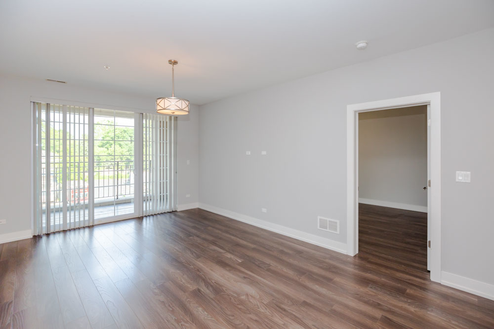 1202 Waukegan Road, Unit 410 Glenview, IL 60025 - Photo 5 of 15 an empty room with wooden floor and windows