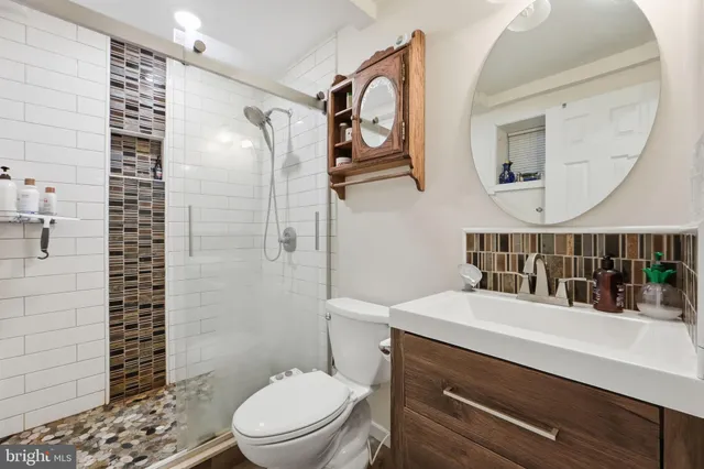 a bathroom with a sink a toilet and shower