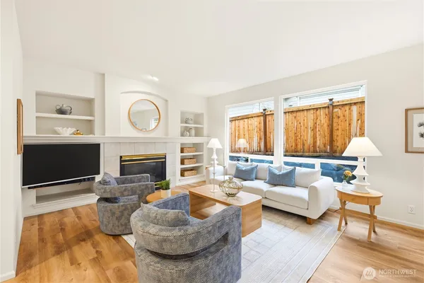 a living room with furniture a large window and a fireplace