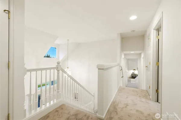 a view of a hallway with white walls and stairs