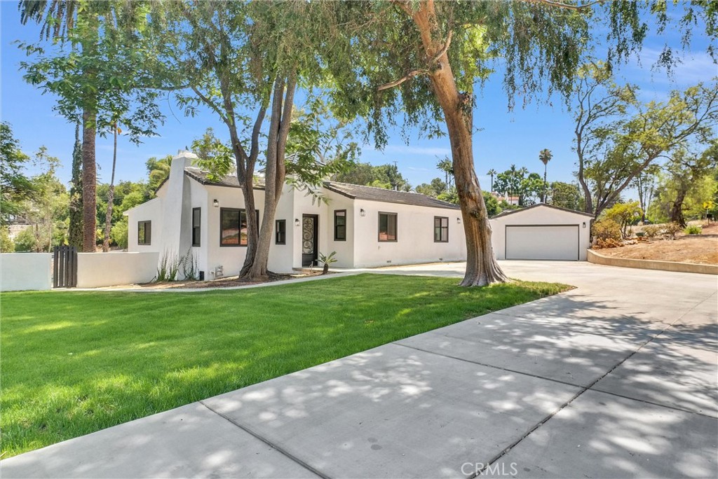 a view of a house with backyard and a tree