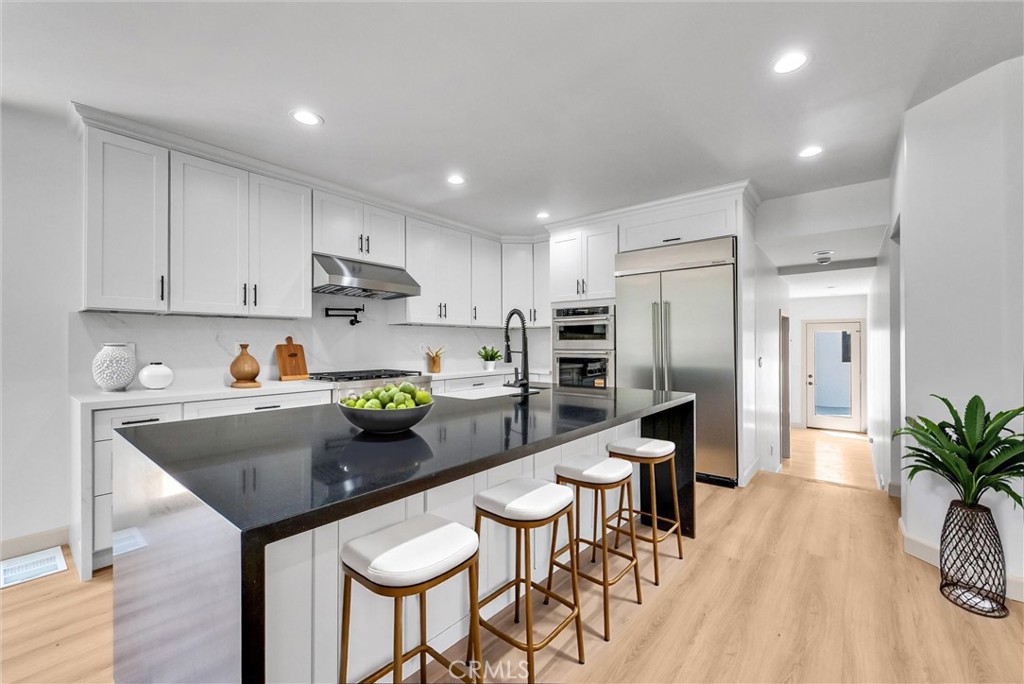 5090 Rockledge Drive Riverside, CA 92506 - Photo 12 of 40 a kitchen with stainless steel appliances granite countertop a table chairs refrigerator and a sink