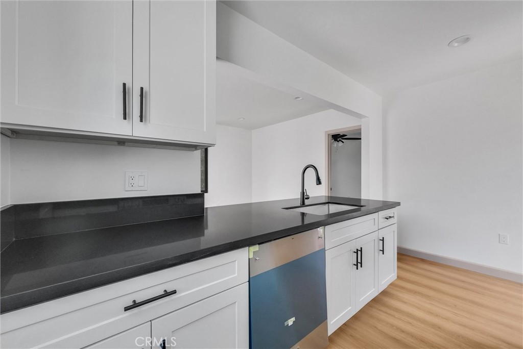 5090 Rockledge Drive Riverside, CA 92506 - Photo 32 of 40 a kitchen with granite countertop white cabinets and a sink