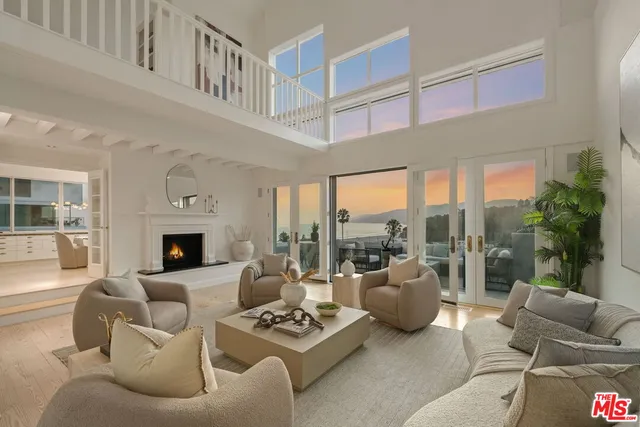 a living room with furniture a fireplace and a floor to ceiling window