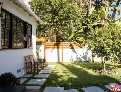a view of a house with backyard and sitting area