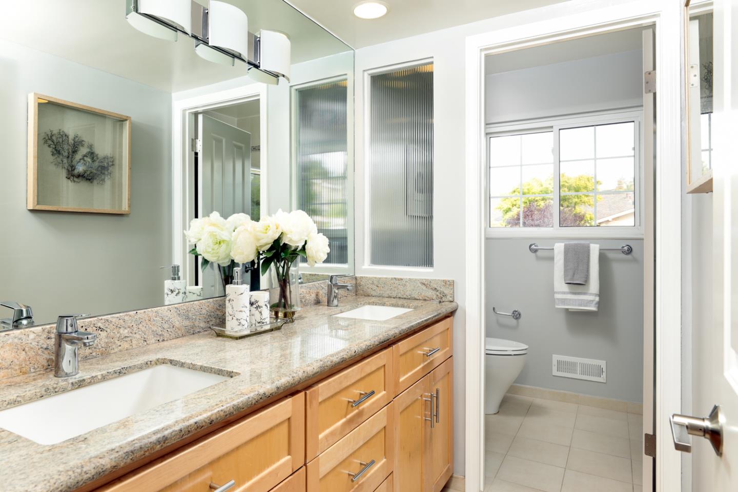 2250 Vía Maderos Los Altos, CA 94024 - Photo 17 of 36 a bathroom with a granite countertop sink a toilet and a mirror