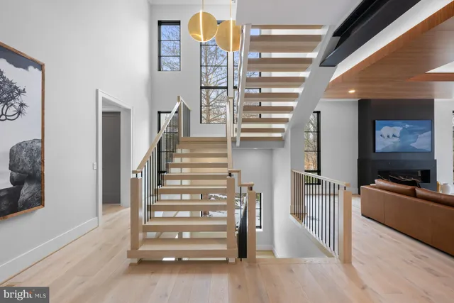 a view of a hallway with stairs and wooden floor