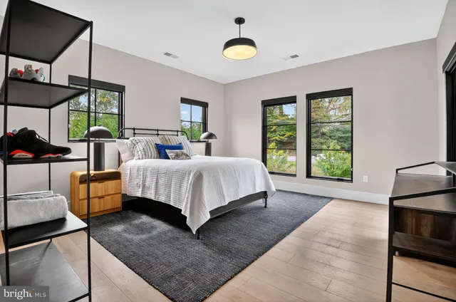 a bedroom with a bed wooden floor and window