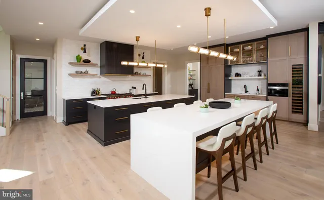 a kitchen with a dining table chairs stainless steel appliances and cabinets