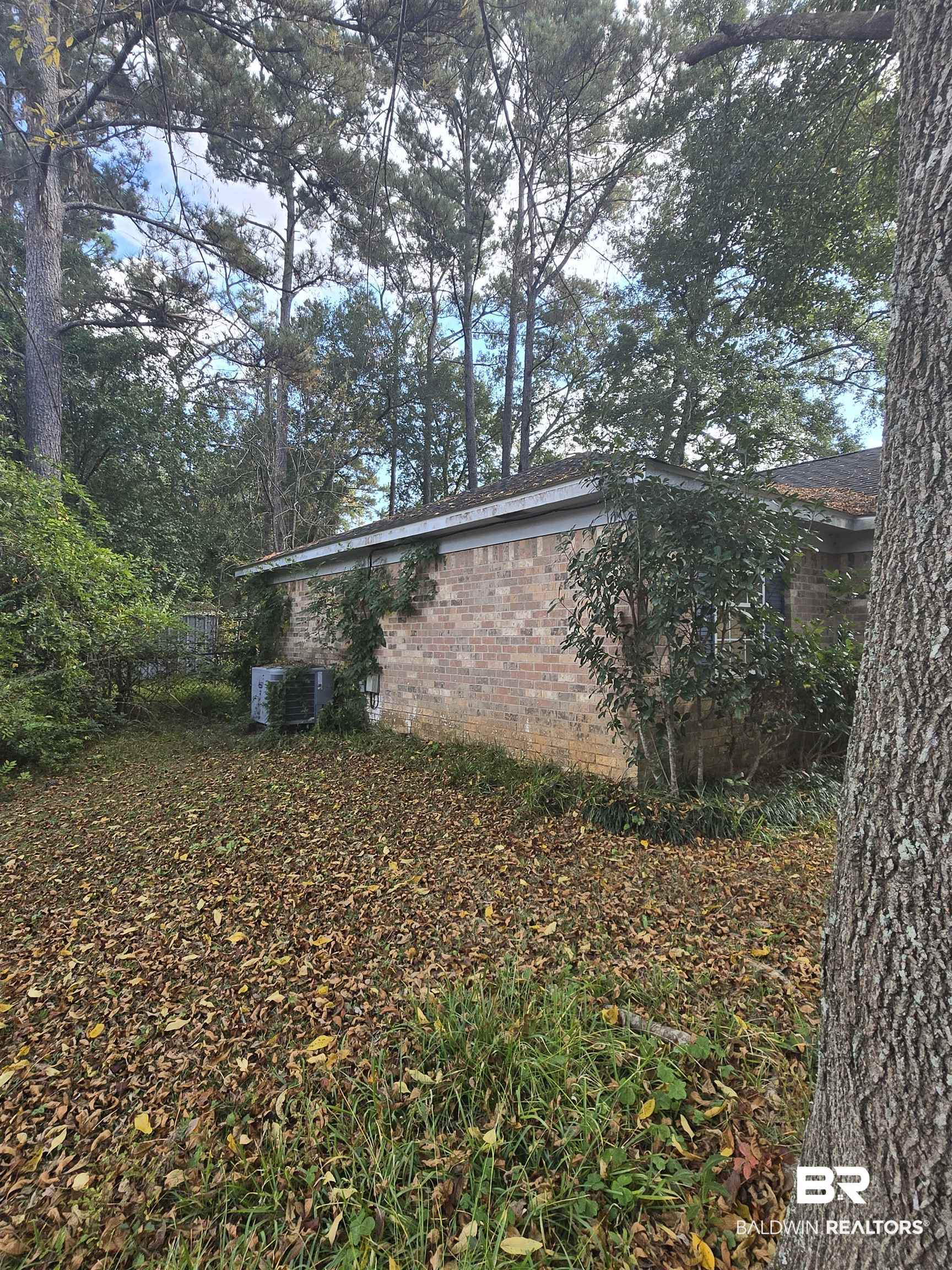 1820 North Cedar Street Foley, AL 36535 - Photo 6 of 14 View of side of home with brick siding and a cooling unit