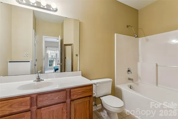 a bathroom with a sink a toilet a mirror a bathtub and shower