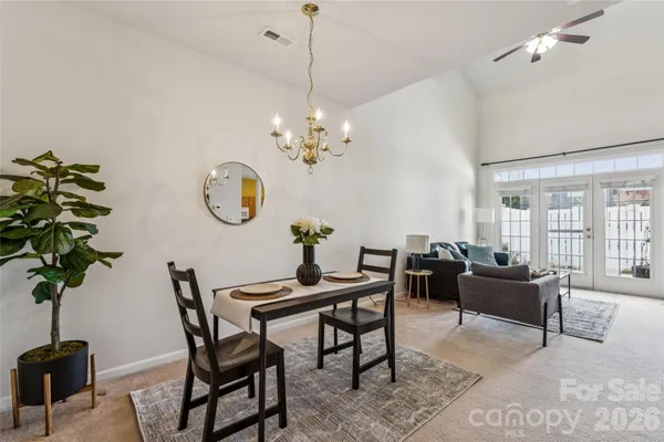 a living room with furniture a chandelier a rug and a window
