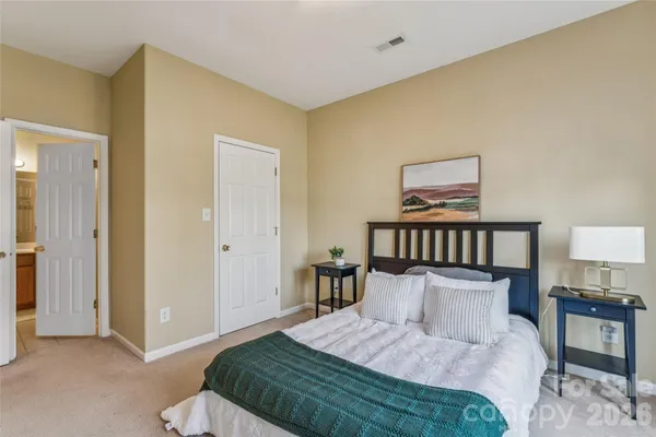 a bedroom with a bed and a lamp on dresser