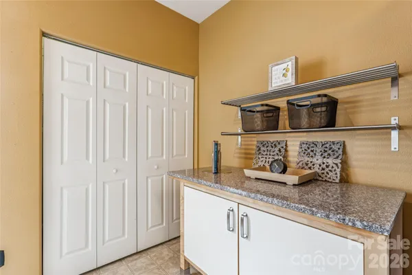 a kitchen with granite countertop white cabinets and stainless steel appliances