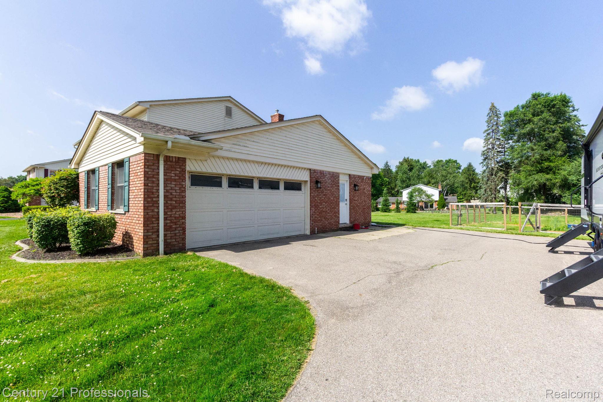 671 Bridgestone Drive Rochester, MI 48309 - Photo 43 of 50 Brick facade with white siding and a two-car garage