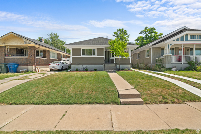 Single-story residence featuring horizontal siding, a gabled roof, and a mature front yard tree