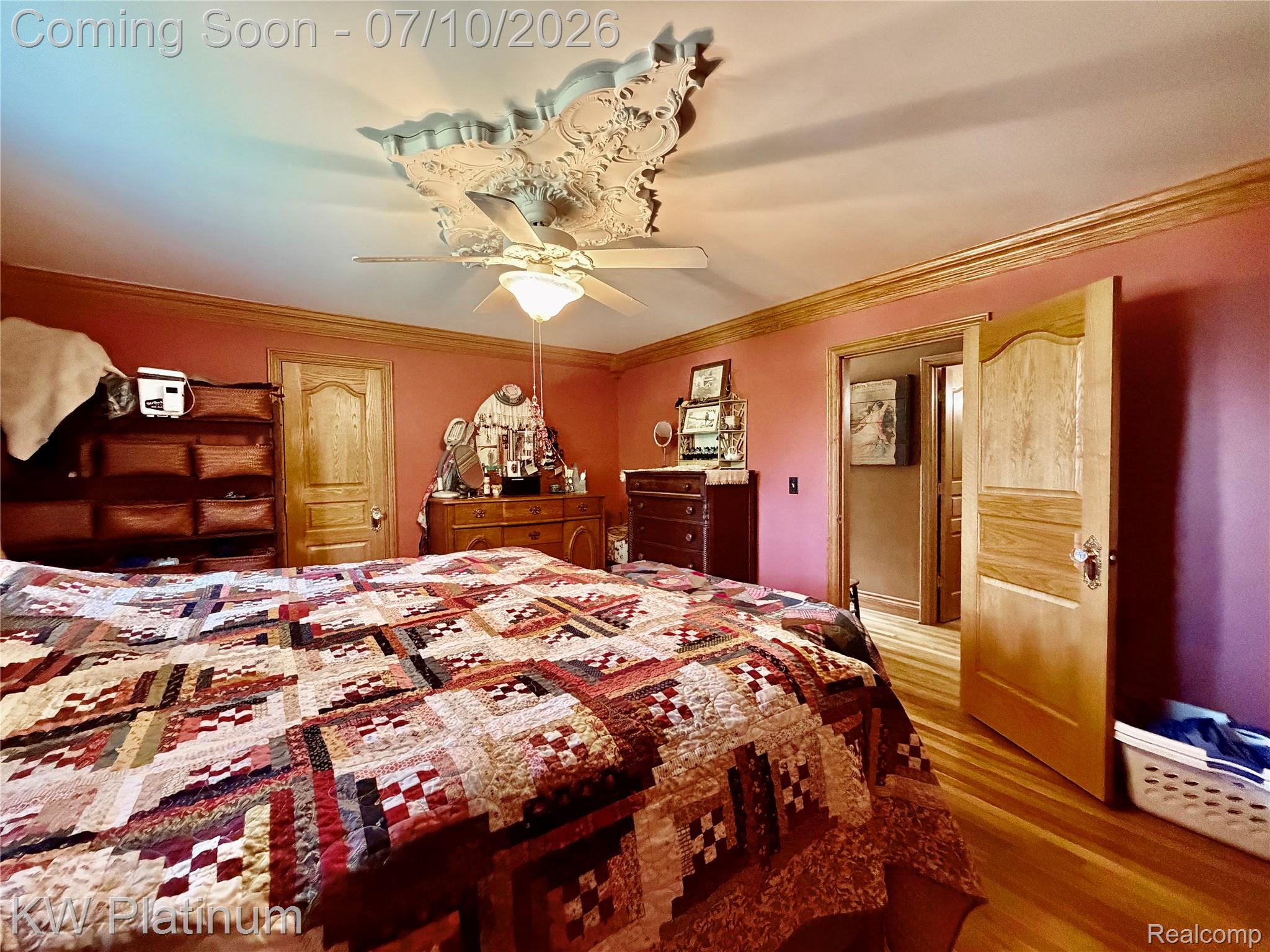 1581 Emerson Road Goodells, MI 48027 - Photo 14 of 45 Room featuring wood-finish flooring, an ornate ceiling medallion, a ceiling fan with integrated lighting, detailed crown molding, and paneled interior doors