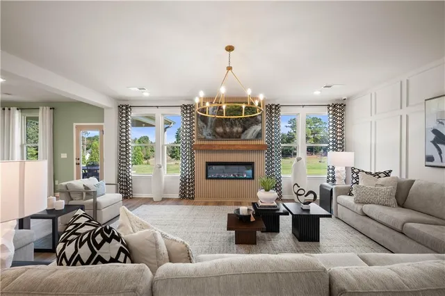 a living room with furniture chandelier and a fireplace