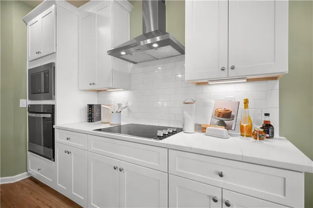 a kitchen with white cabinets and stainless steel appliances