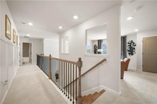 a view of a hallway with furniture and a chandelier