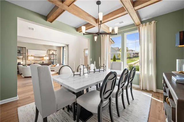 a dining room with furniture a chandelier and wooden floor