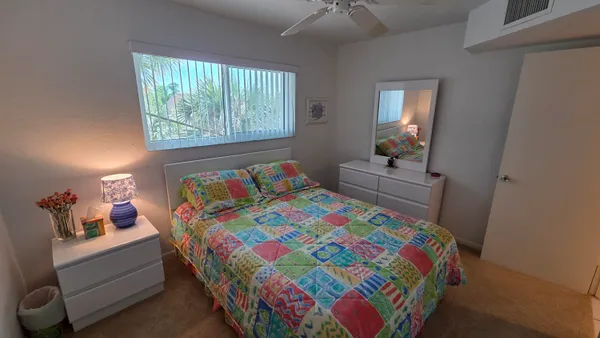 a bedroom with a bed and a lamp on dresser