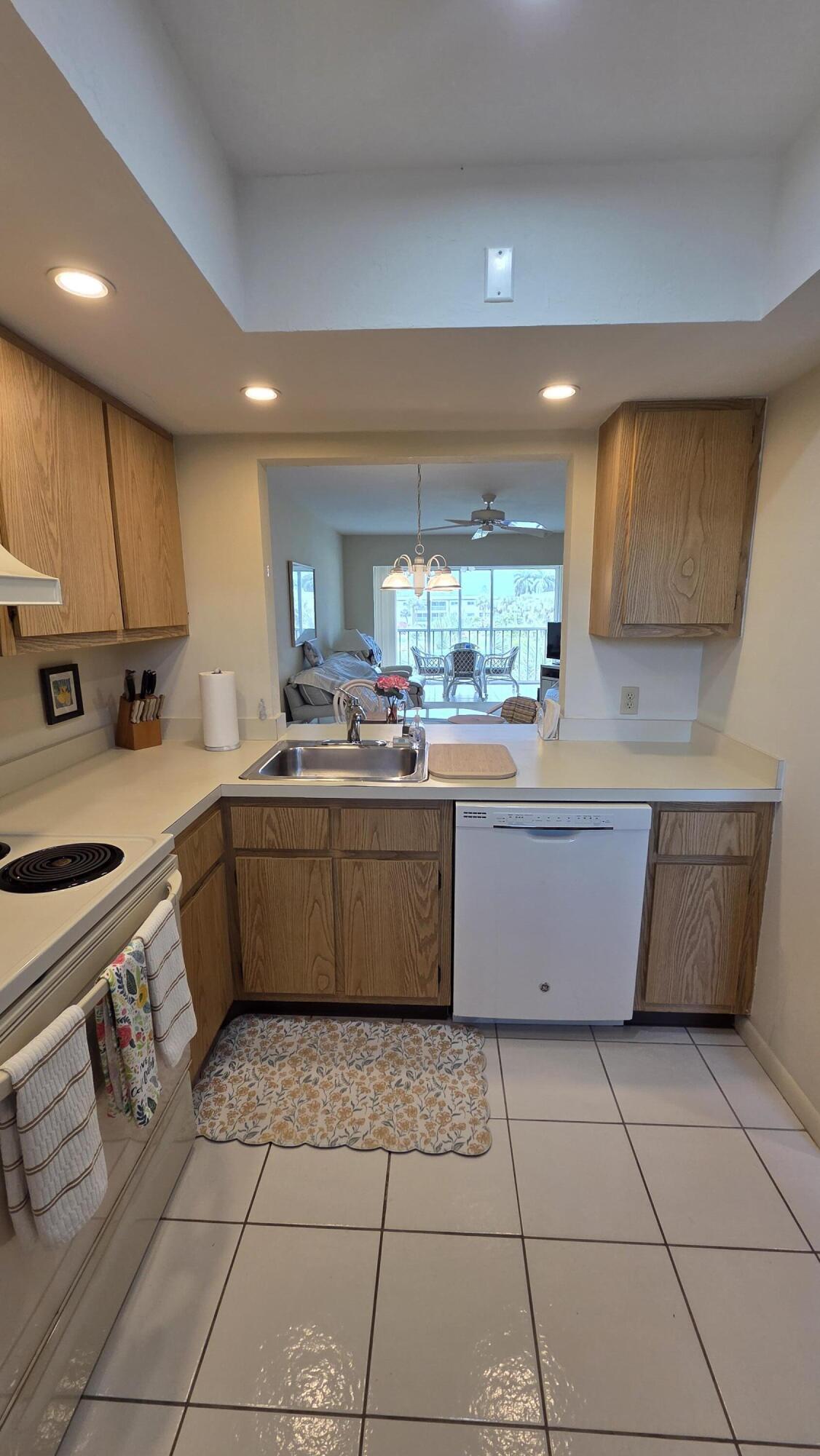 1014 Manatee Road, Unit F303 Naples, FL 34114 - Photo 3 of 22 a kitchen with a sink a stove a microwave and cabinets