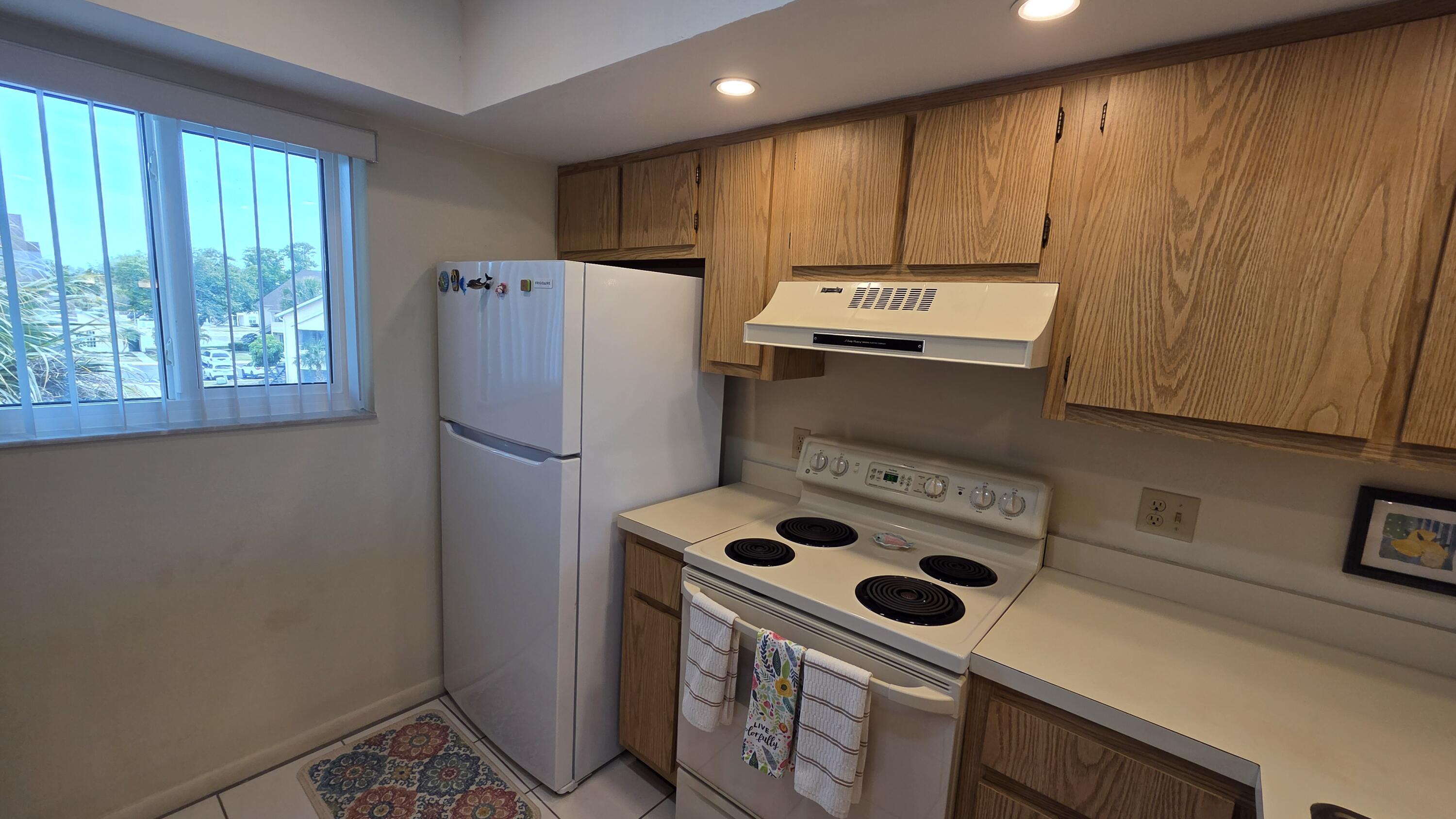 1014 Manatee Road, Unit F303 Naples, FL 34114 - Photo 4 of 22 a kitchen with a refrigerator and a stove