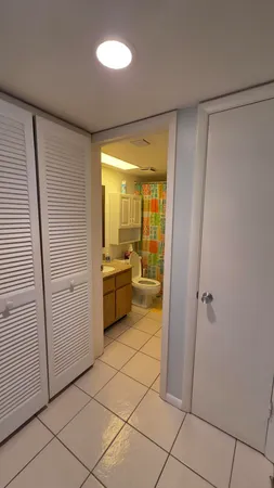 a view of a hallway to rooms and a kitchen with a sink