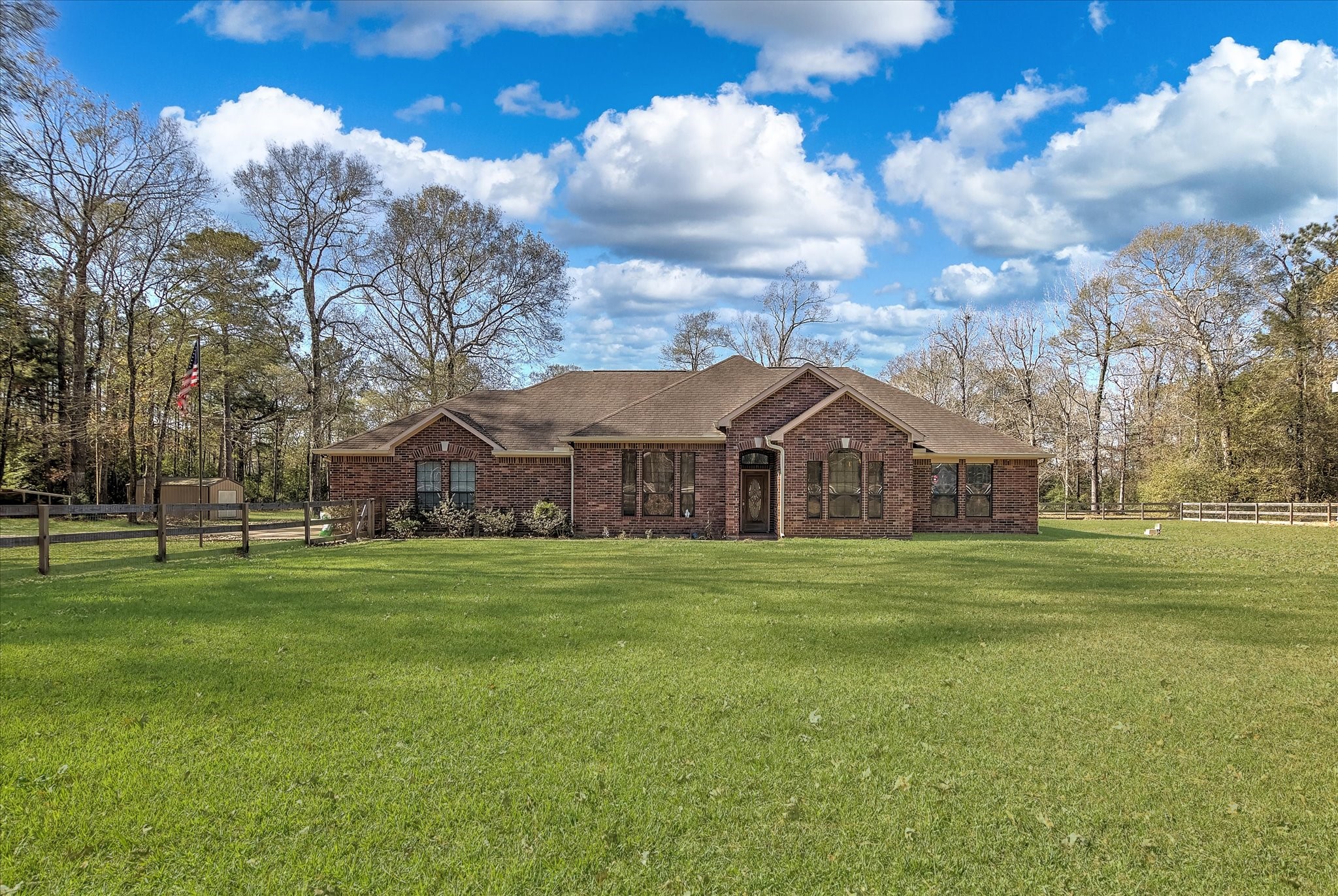 a front view of a house with a big yard and a large tree