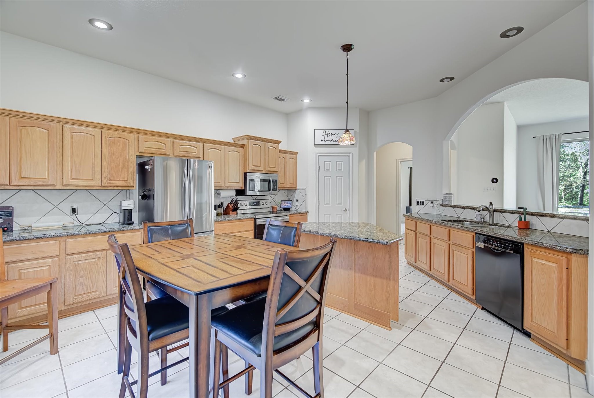 3850 Farm To Market 1010 Road Cleveland, TX 77327 - Photo 14 of 49 a kitchen with stainless steel appliances granite countertop a kitchen island a stove a table and chairs in it