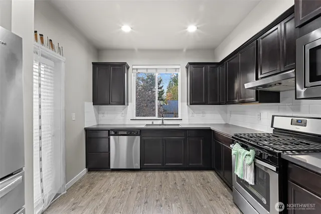 a kitchen with stainless steel appliances granite countertop wooden cabinets stove top oven and sink