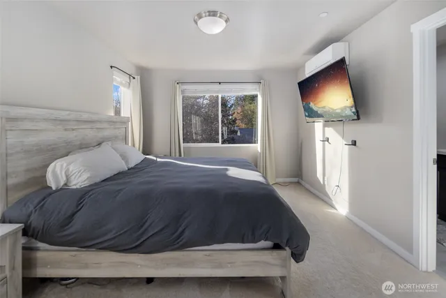a bedroom with a bed tv and window