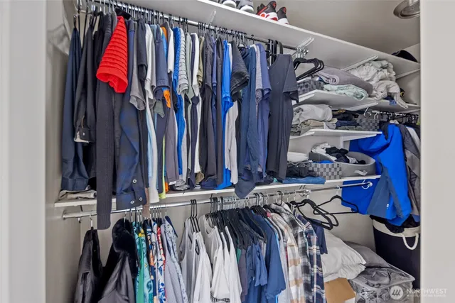 a view of walk in closet with clothes and shoes