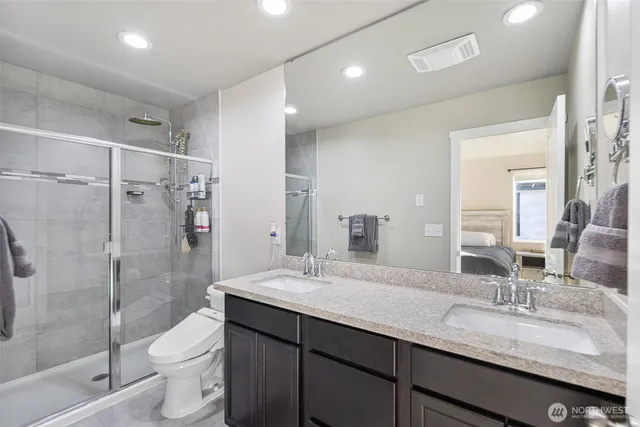 a bathroom with a granite countertop sink toilet and shower