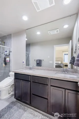 a bathroom with a granite countertop sink a toilet and a mirror
