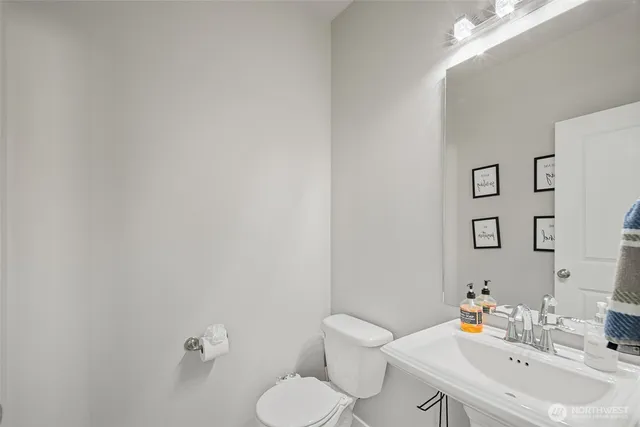 a bathroom with a sink mirror and toilet