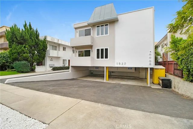 a view of a white house with a yard and sitting area