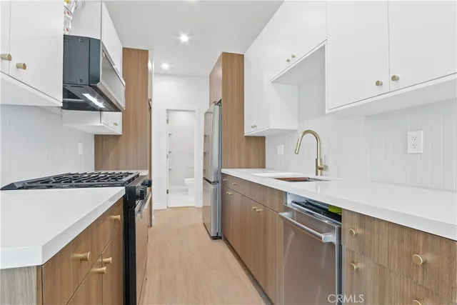 a kitchen with stainless steel appliances granite countertop a sink stove and refrigerator