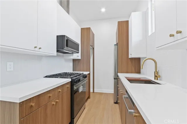 a kitchen with stainless steel appliances granite countertop a sink stove and refrigerator