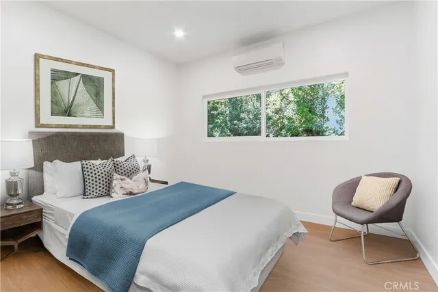 a bedroom with a bed and a painting on the wall