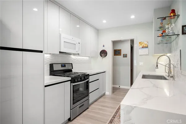 a kitchen with stainless steel appliances granite countertop a sink and a stove