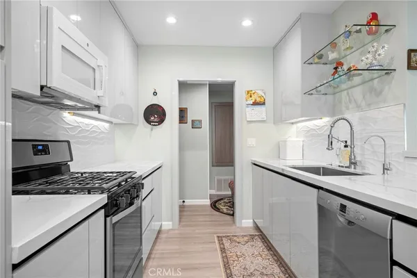 a large kitchen with stainless steel appliances granite countertop a sink and cabinets