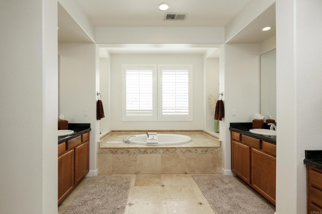 1446 Old Janal Ranch Road Chula Vista, CA 91915 - Photo 25 of 51 a spacious bathroom with a tub sink and mirror