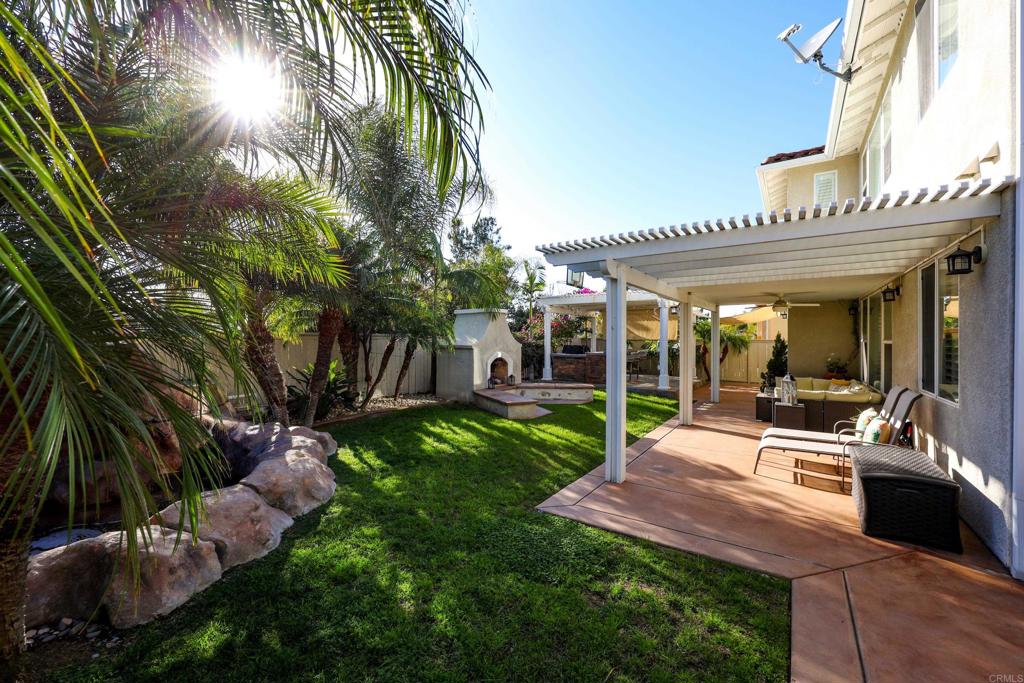 1446 Old Janal Ranch Road Chula Vista, CA 91915 - Photo 44 of 51 a view of a patio with table and chairs potted plants and large tree