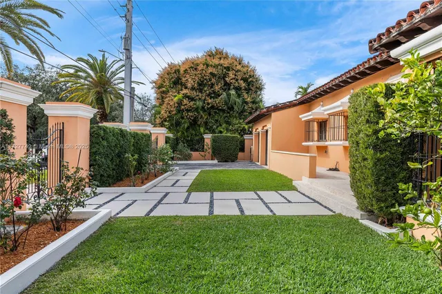 a white house with a yard and potted plants