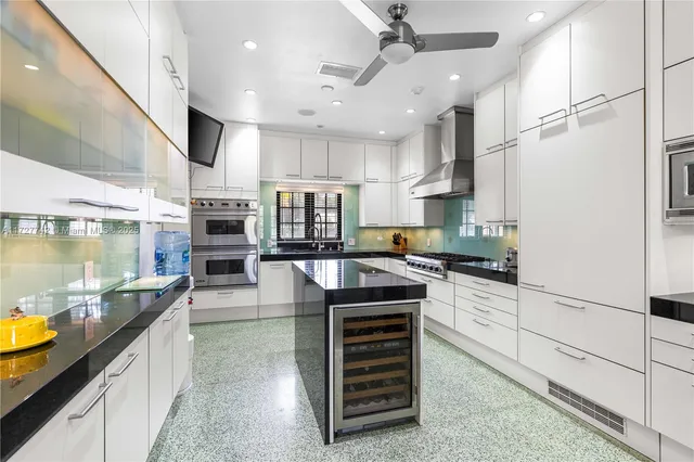 a kitchen with stainless steel appliances a stove a refrigerator and a kitchen island
